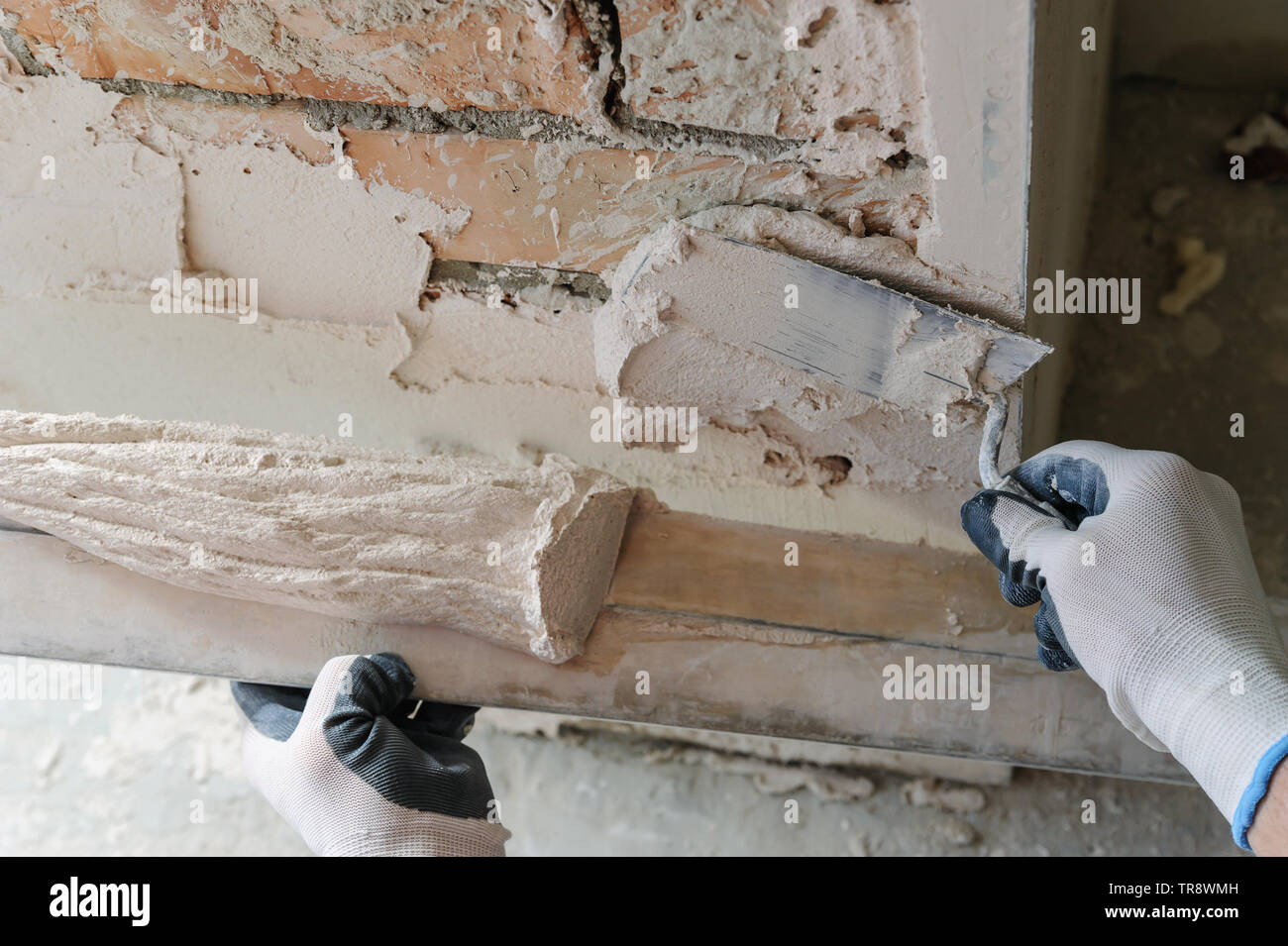 Worker is putting a gypsum plaster on a brick wall. Stock Photo