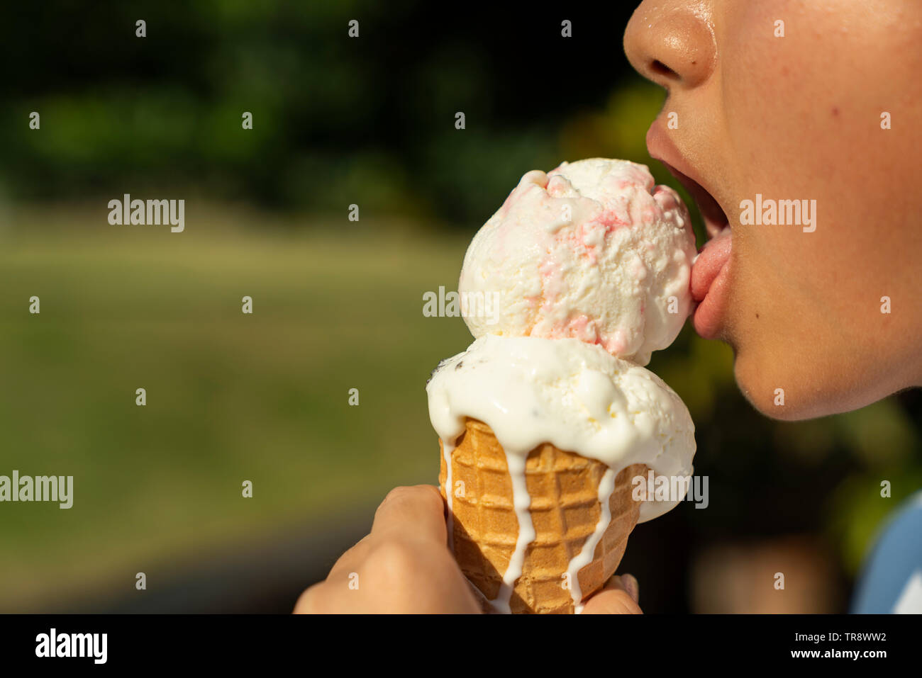 Young chinese boy eating vanilla cone ice cream Stock Photo