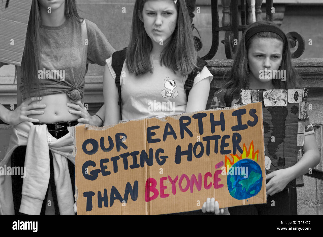 Student holding Our Earth is getting hotter than Beyonce banner sign at ...
