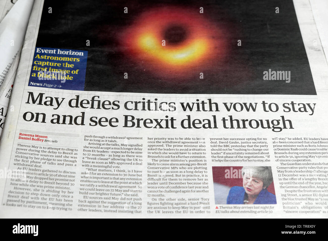 'May defies critics with vow to stay on and see Brexit deal through' Theresa May British newspaper article headline juxtaposed with first photo of black hole in space by astronomers in London UK Europe EU 10 April 2019 Stock Photo