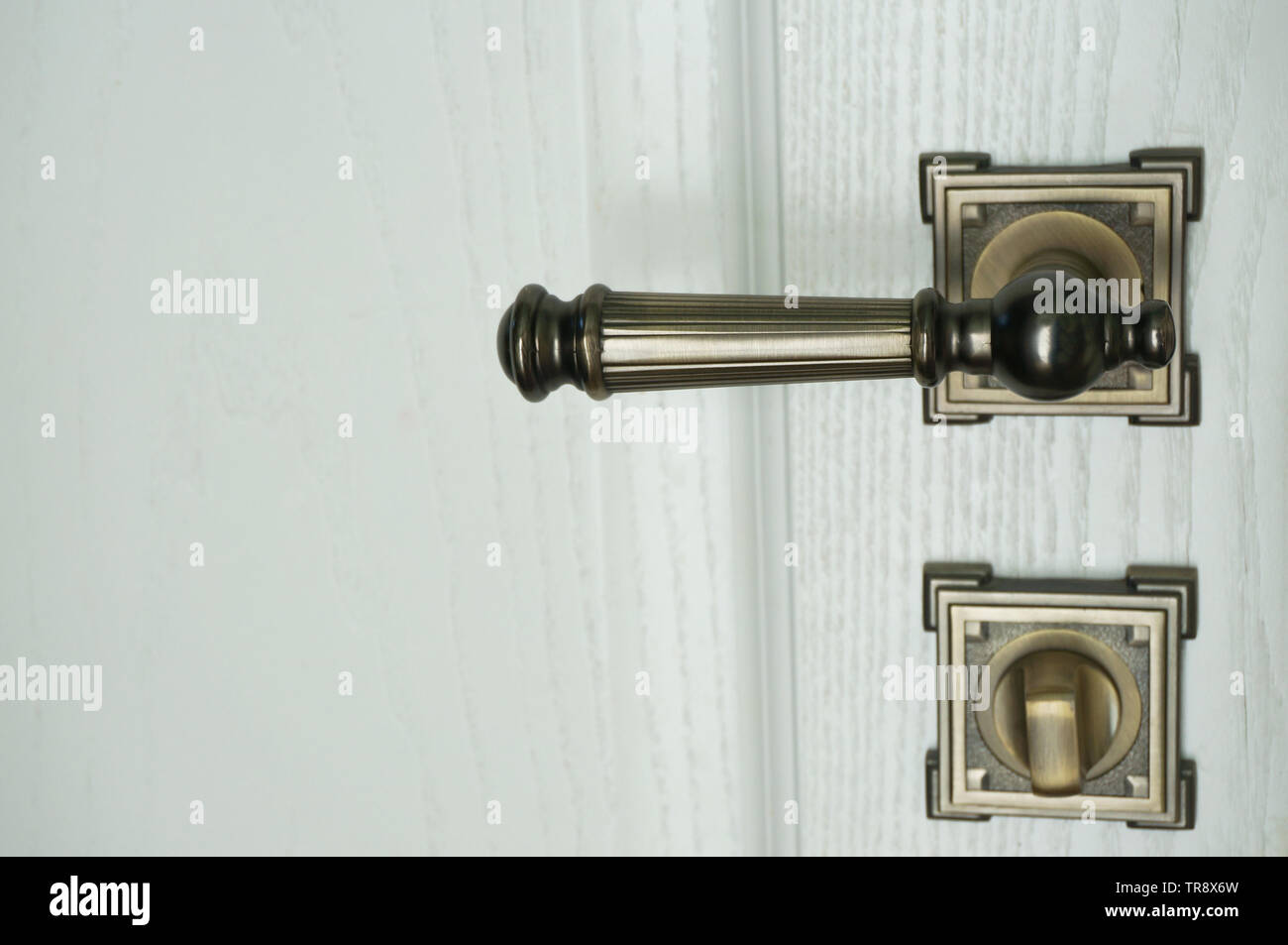 Metal bronze color door handle and lock in close on white door Stock Photo Alamy