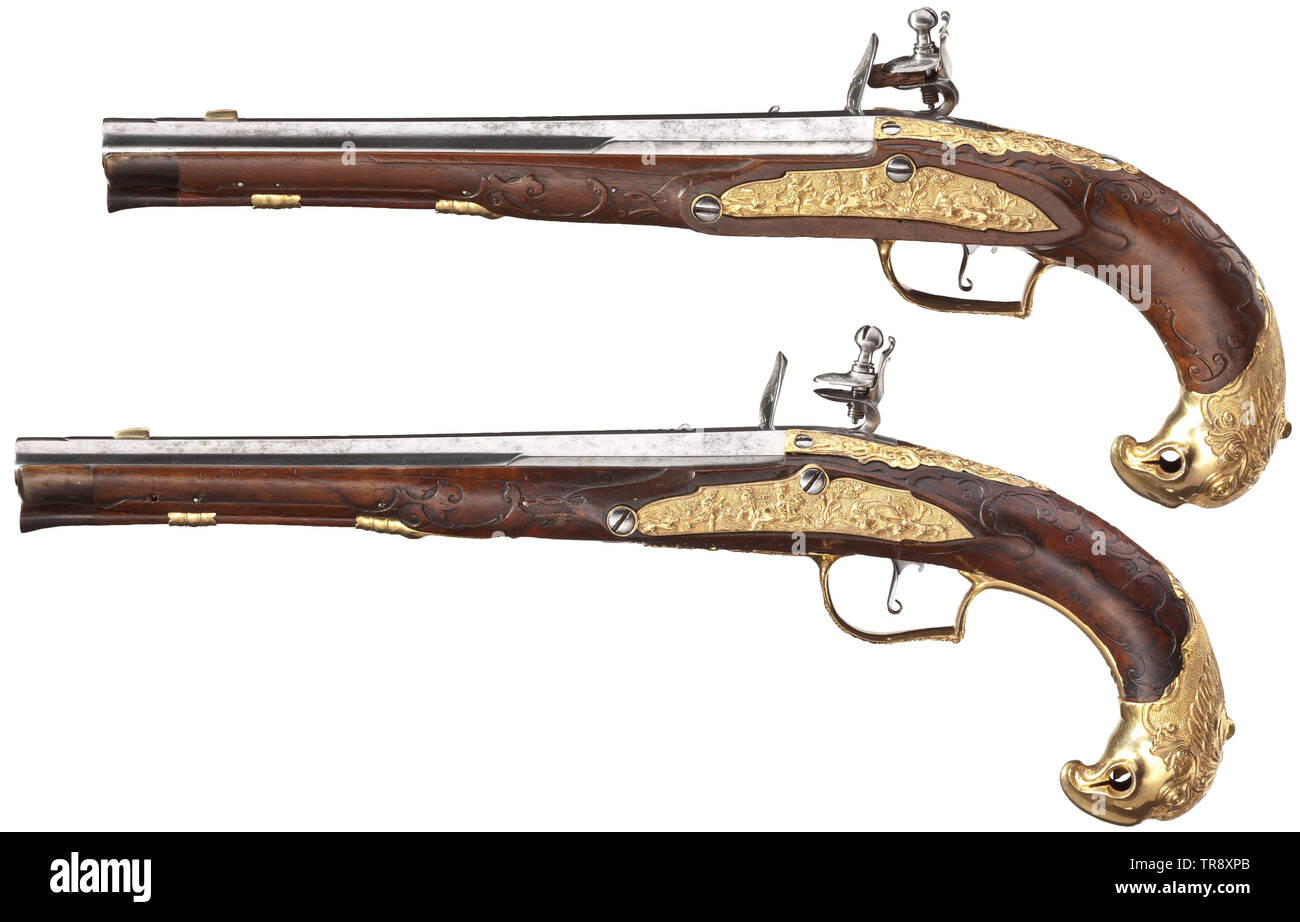 A pair of magnificent flintlock pistols, Karlovy Vary, circa 1760 Round barrels with flattened midrib, smooth bores in 13 mm calibre. Flintlocks with finely engraved depiction of a sitting huntress with dogs, beside her fleeing red deer. Slightly carved full stocks made from walnut with noses made from dark horn. Furnitures made from fire-gilt brass in lavish relief. The side plates with multi-figured hunting scenes, the pommels shaped like sculptural bird's heads. Original, wooden ramrods with horn tips. Length 39 cm each. High-grade pair of pis, Additional-Rights-Clearance-Info-Not-Available Stock Photo