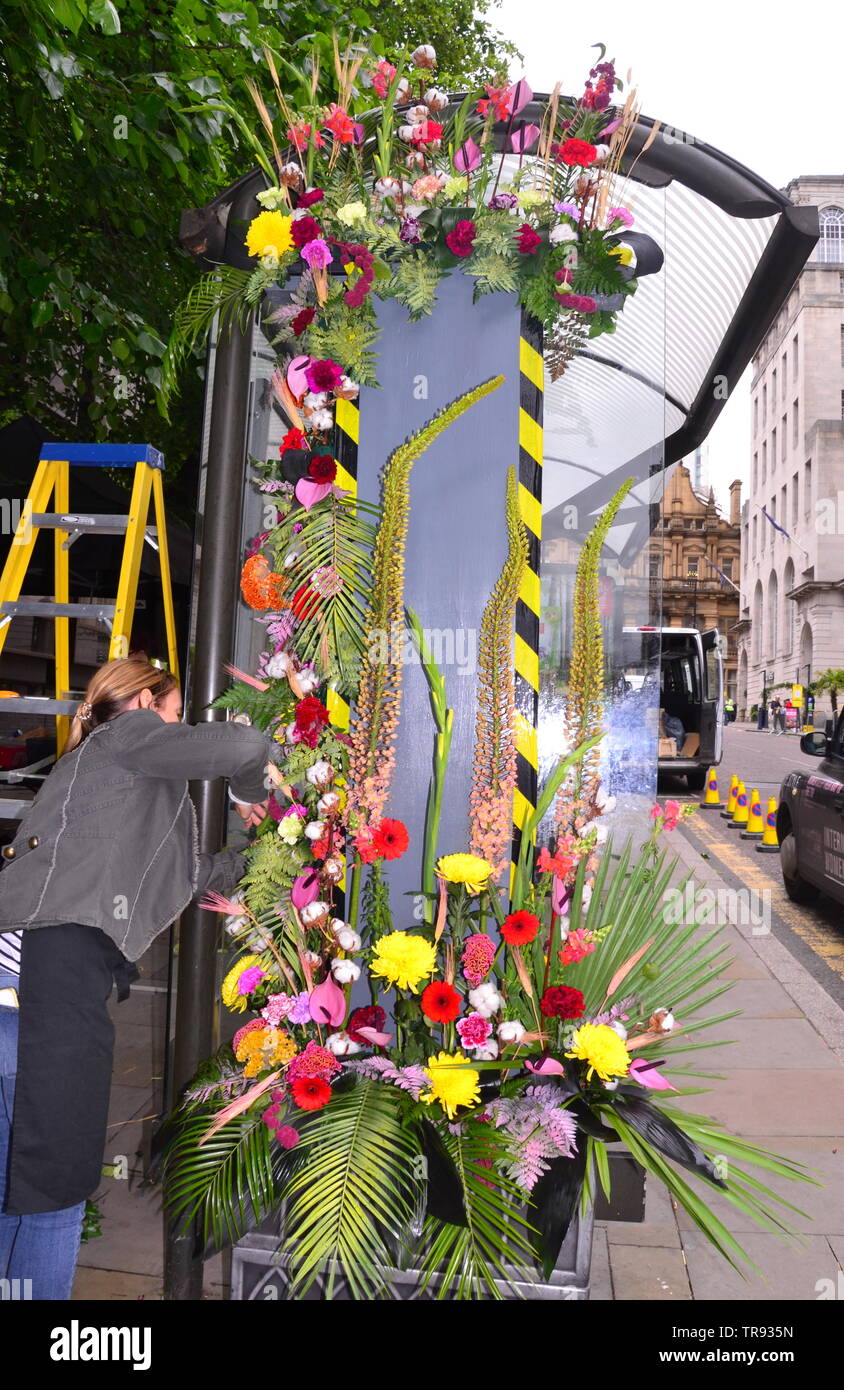 The Manchester Flower Show, part of Manchester's King Street  Festival on June 1st - 2nd, 2019, prepares to open. This year’s theme:Flower Power! Flowers decorate a bus stop. Stock Photo
