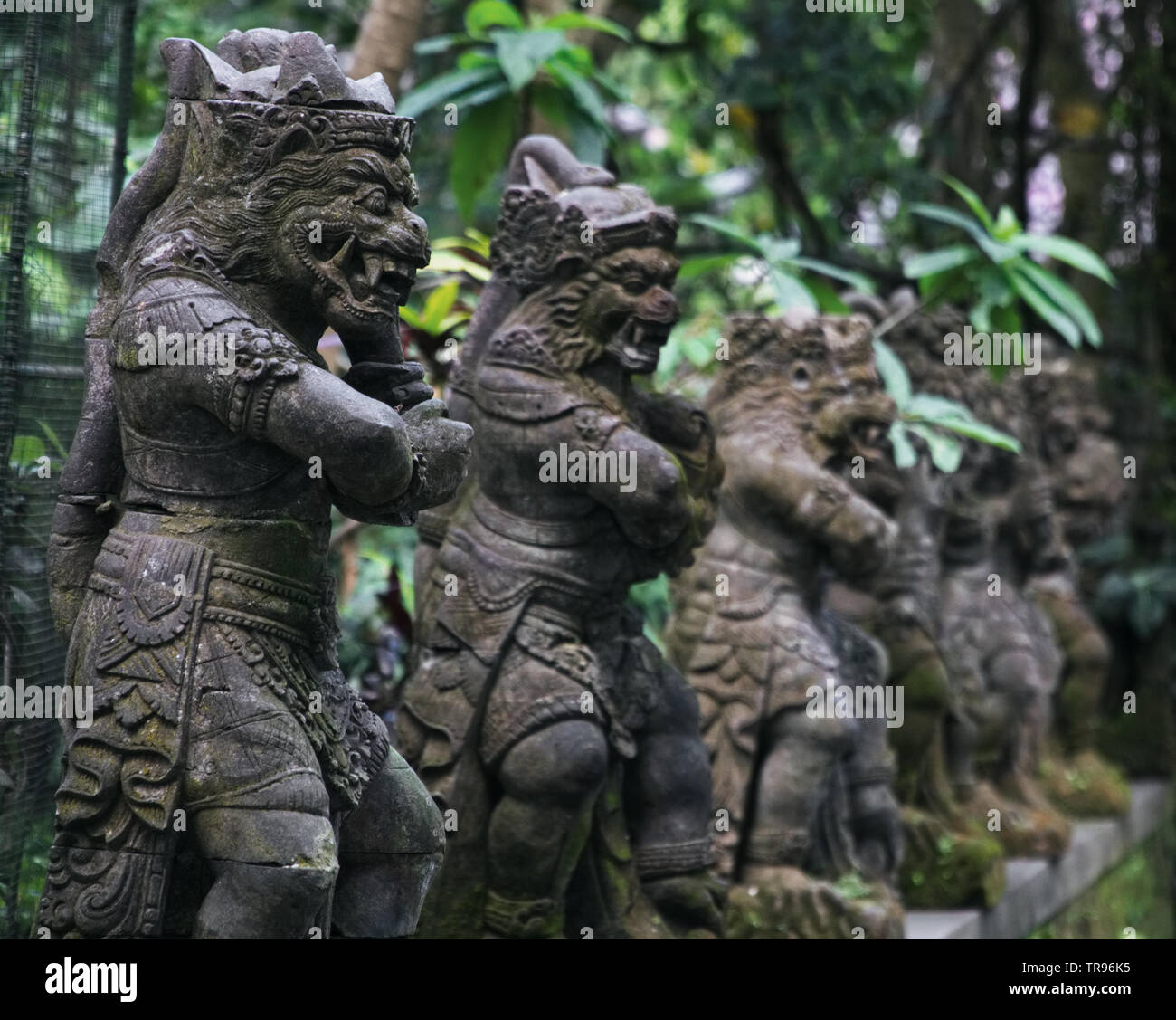 ancient looking indonesian statues in the monkey forest in bali Stock