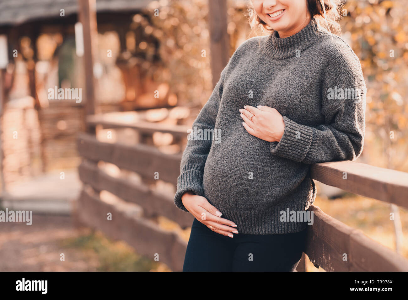 Smiling pregnant woman wearing cozy 