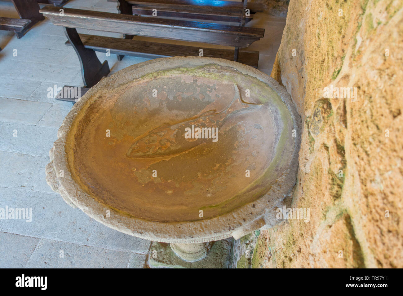 Ancient font with a fish engraving in the 5th Century church of San Giovanni di Sinis, near Cabras, Sardinia, Italy Stock Photo