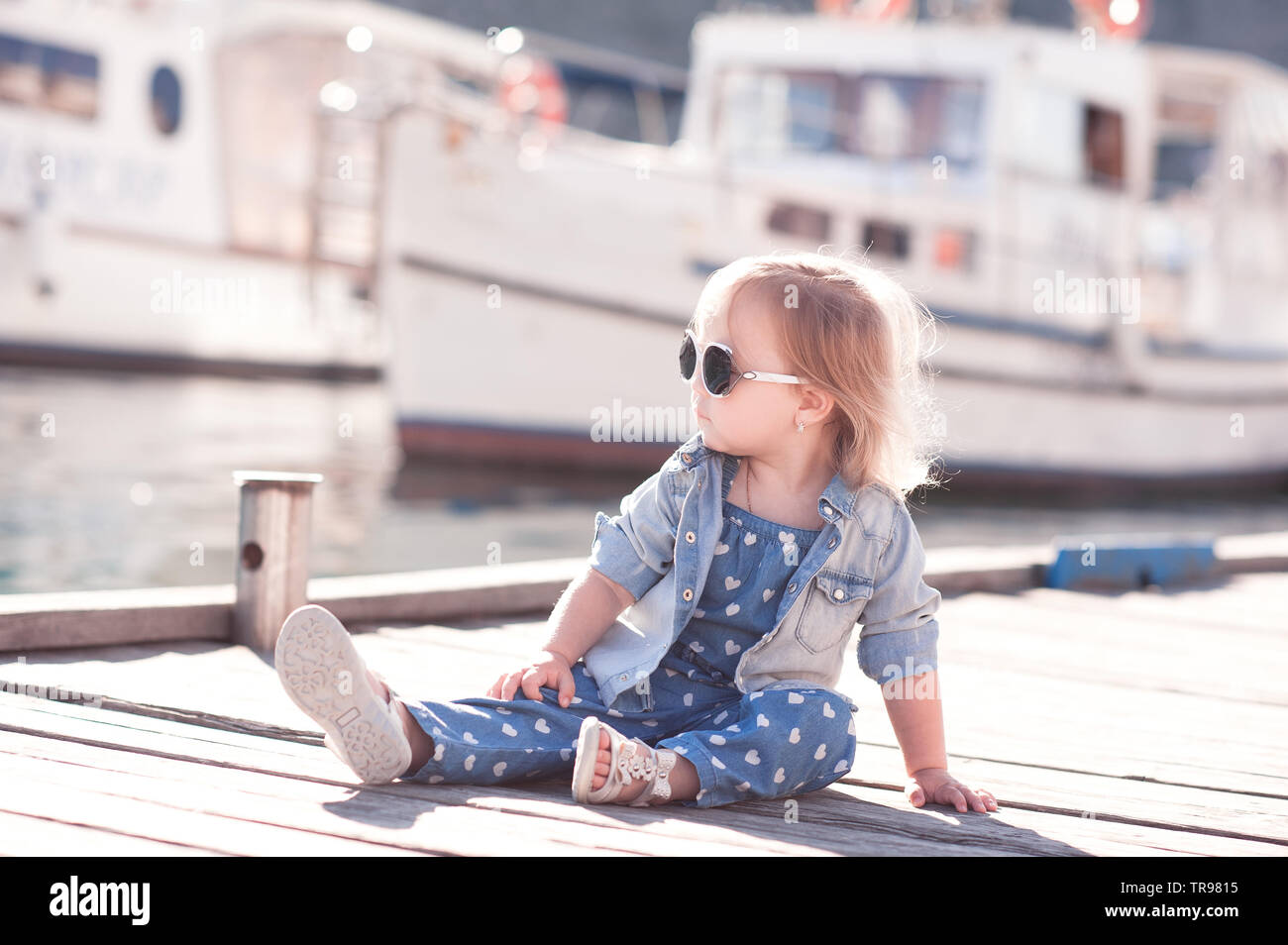 Cute kid girl 1-2 year old wearing stylish clothes over city background.  Looking at camera. Childhood Stock Photo - Alamy