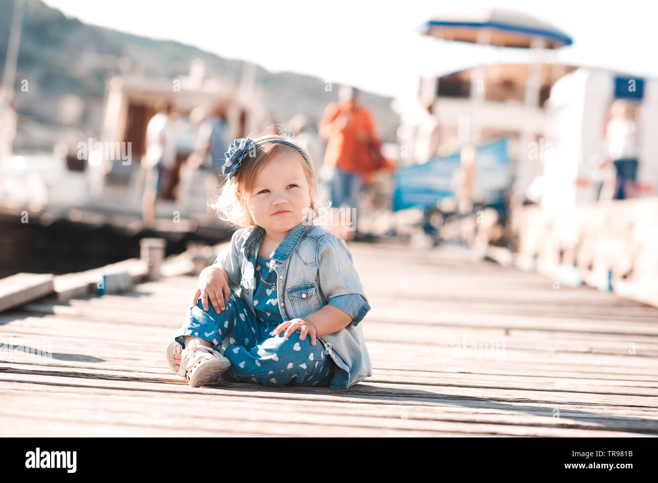 Cute kid girl 1-2 year old wearing stylish clothes over city background.  Looking at camera. Childhood Stock Photo - Alamy