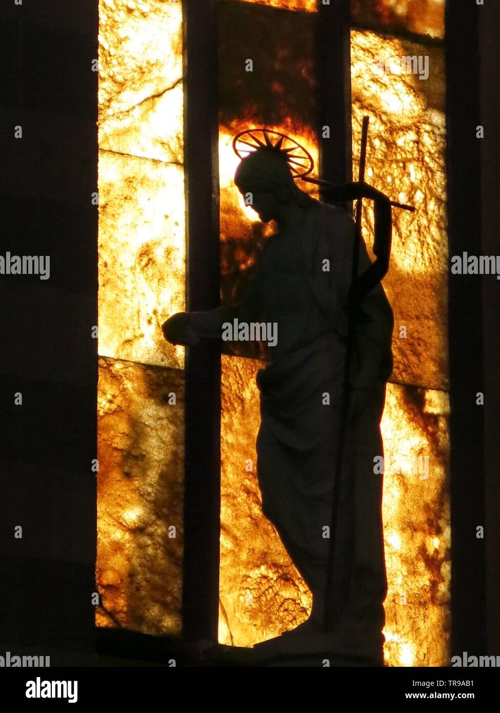 Closeup of statue of a religious figure on the top of the baptismal