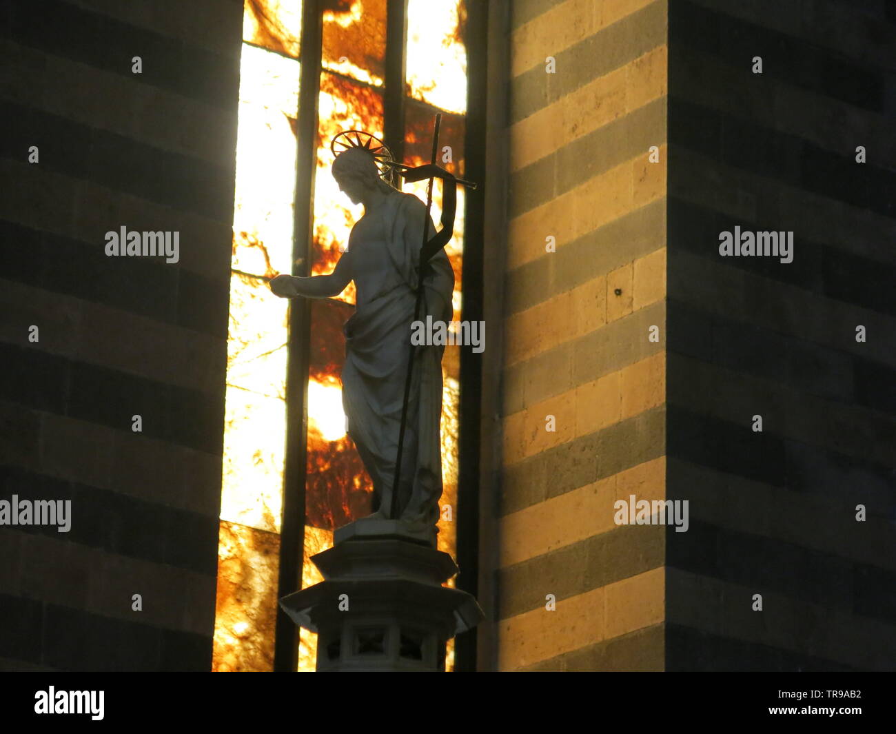 Closeup of statue of a religious figure on the top of the baptismal