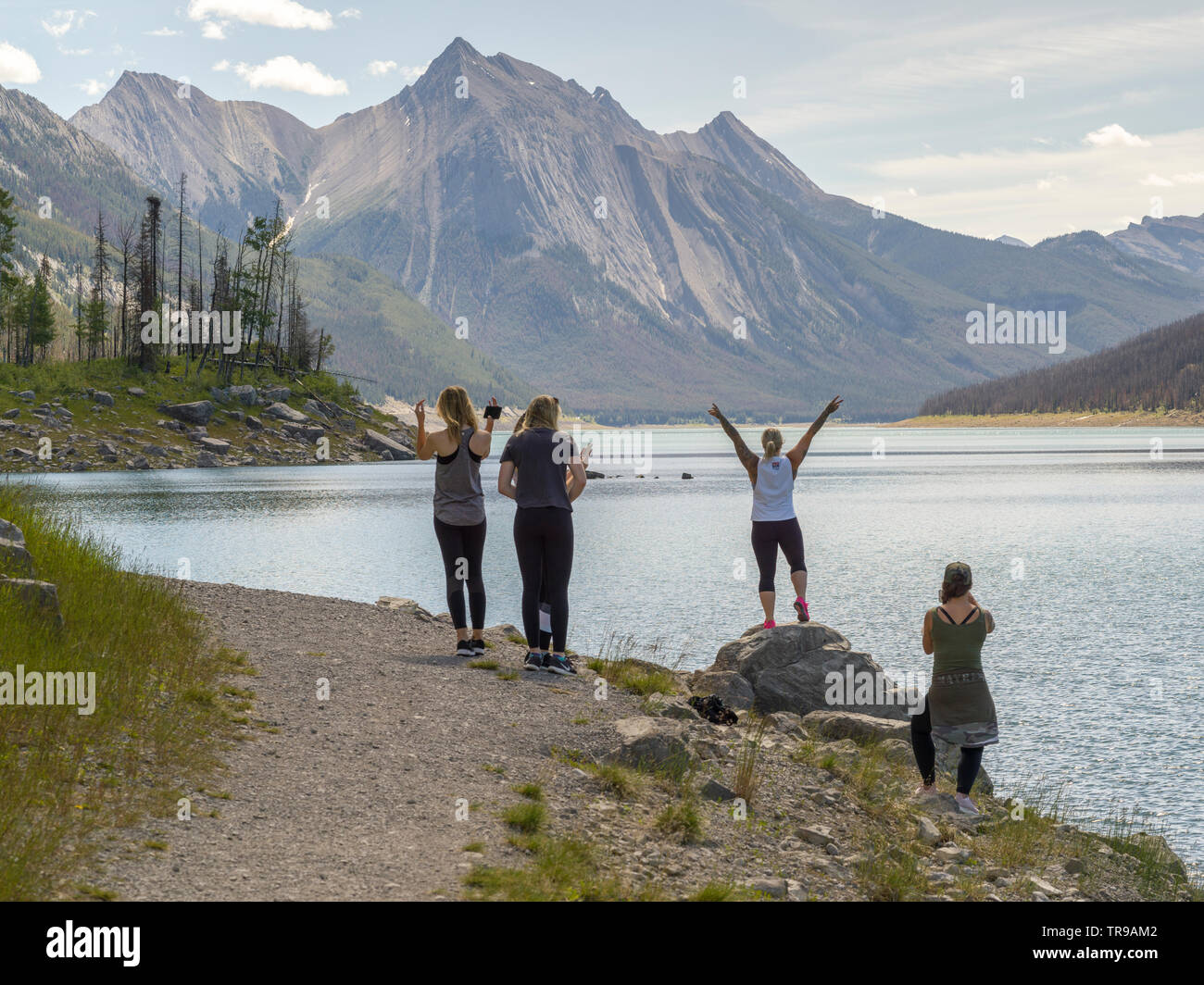 Enthusiastic tourists at lakeside, Medicine Lake, Maligne Lake Road, Jasper National Park, Jasper, Alberta, Canada Stock Photo