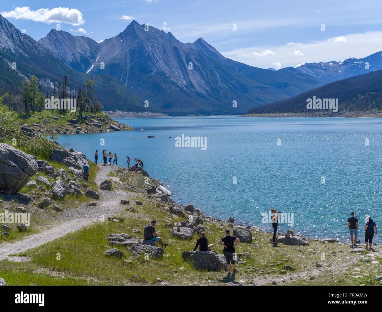 Tourists at lakeside, Medicine Lake, Maligne Lake Road, Jasper National Park, Jasper, Alberta, Canada Stock Photo