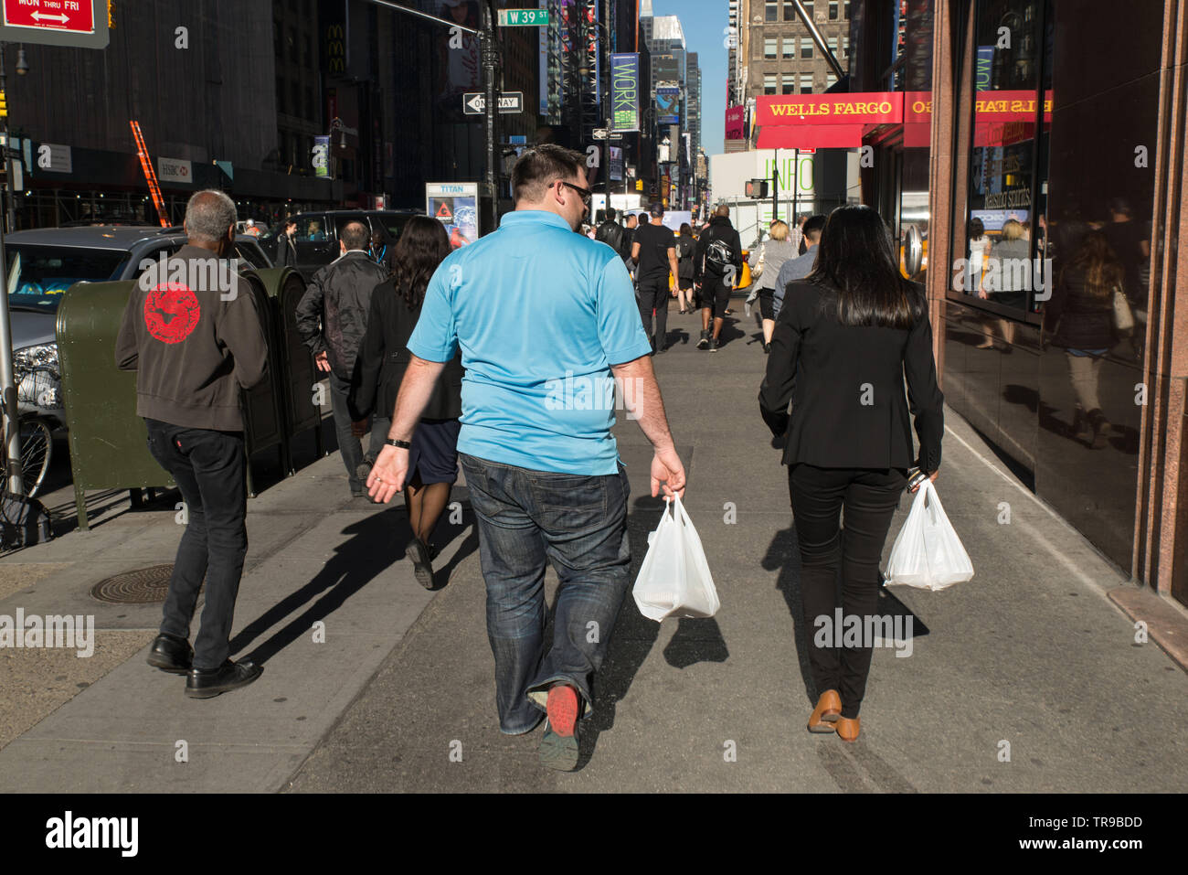 2 people carrying plastic bags at lunchtime, Manhattan, New-York, USA. Stock Photo