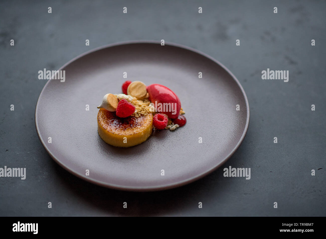 Creme brulee with raspberry, merigne and sorbet Stock Photo