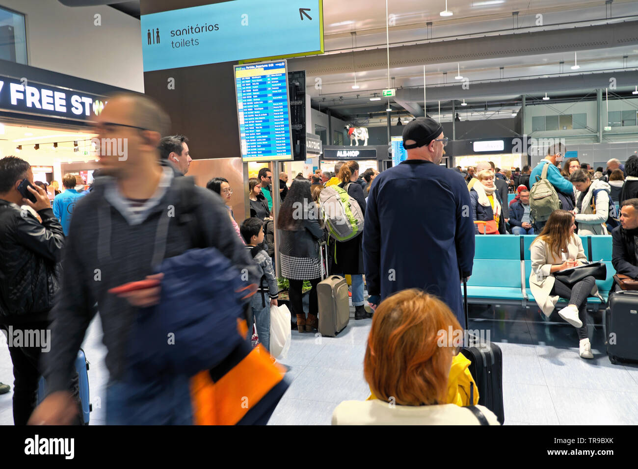 Passengers preparing waiting for flights looking at electronic display board in Lisbon airport departure lounge in April 2019 Lisboa, Portugal Europe Stock Photo