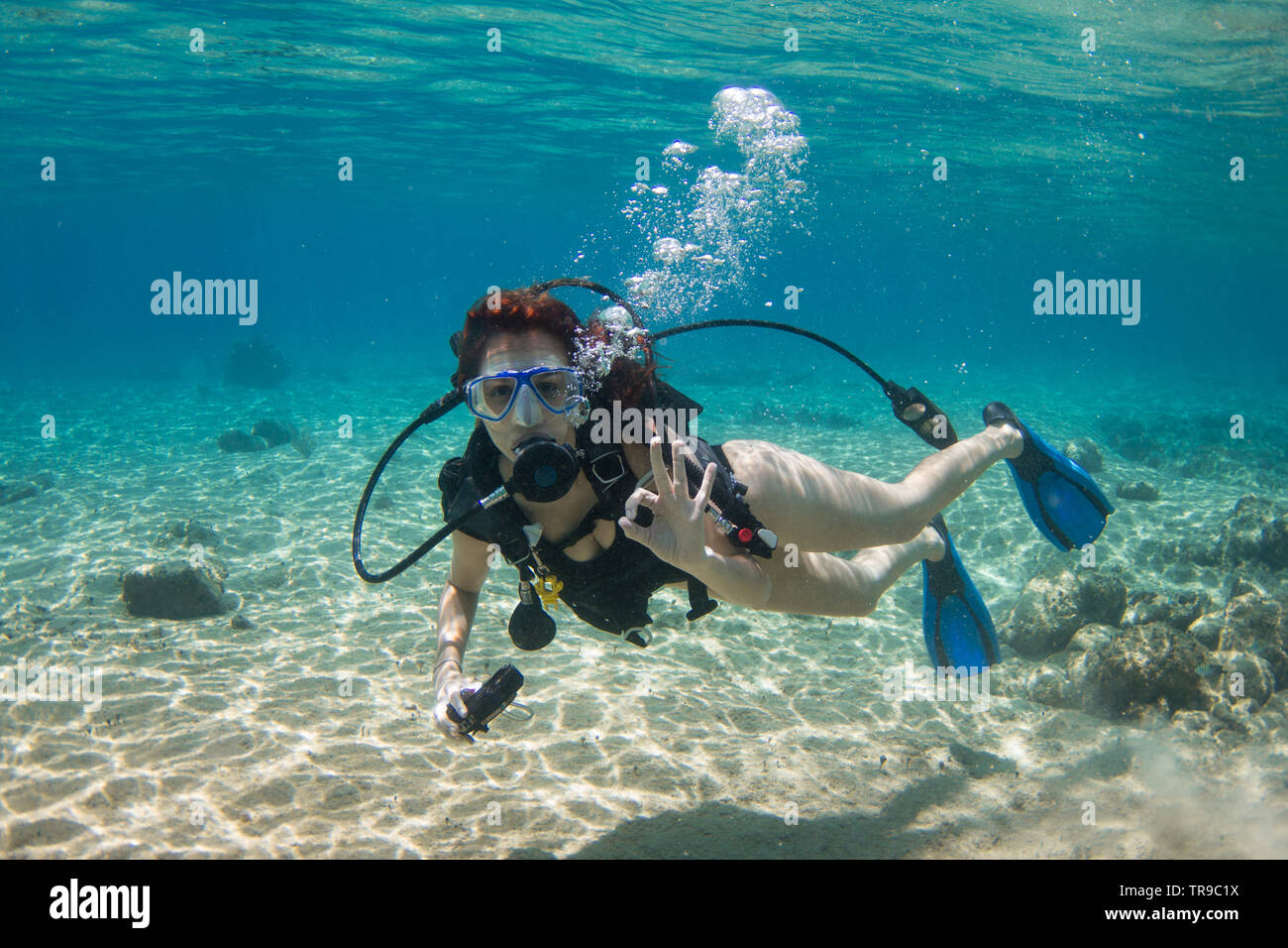 COZUMEL, MEXICO: woman scuba diver making ok signal underwater in a turquoise sea Stock Photo