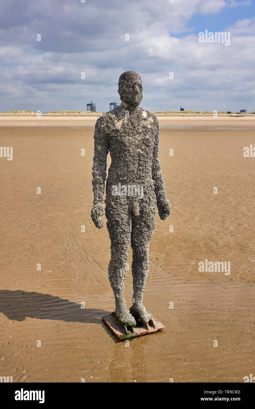 One of Anthony Gormley’s statues ‘Another Time’ set into the sand at Crosby beach, Merseyside Stock Photo