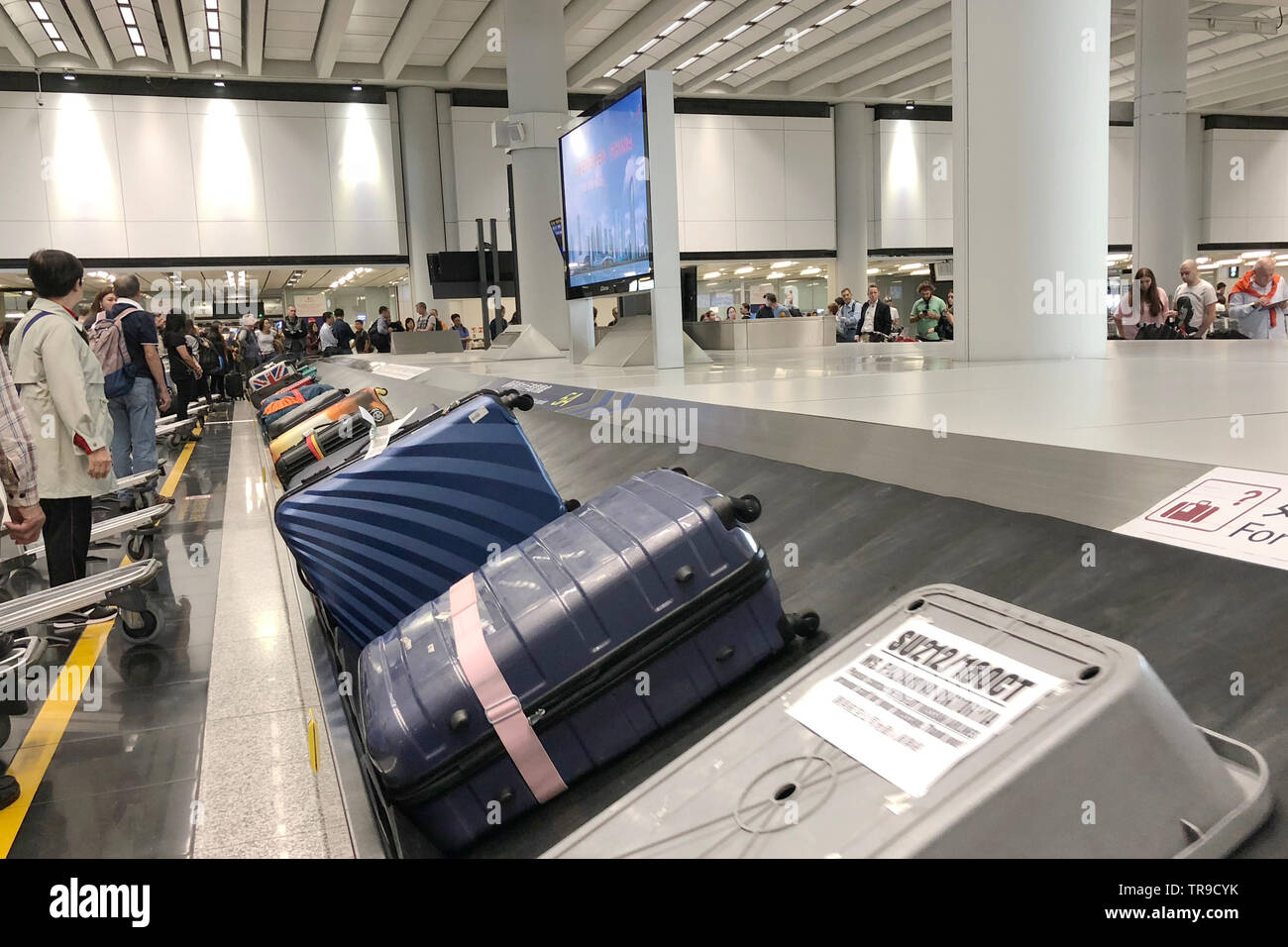 Luggage conveyor belt with personal suitcases moving around circle
