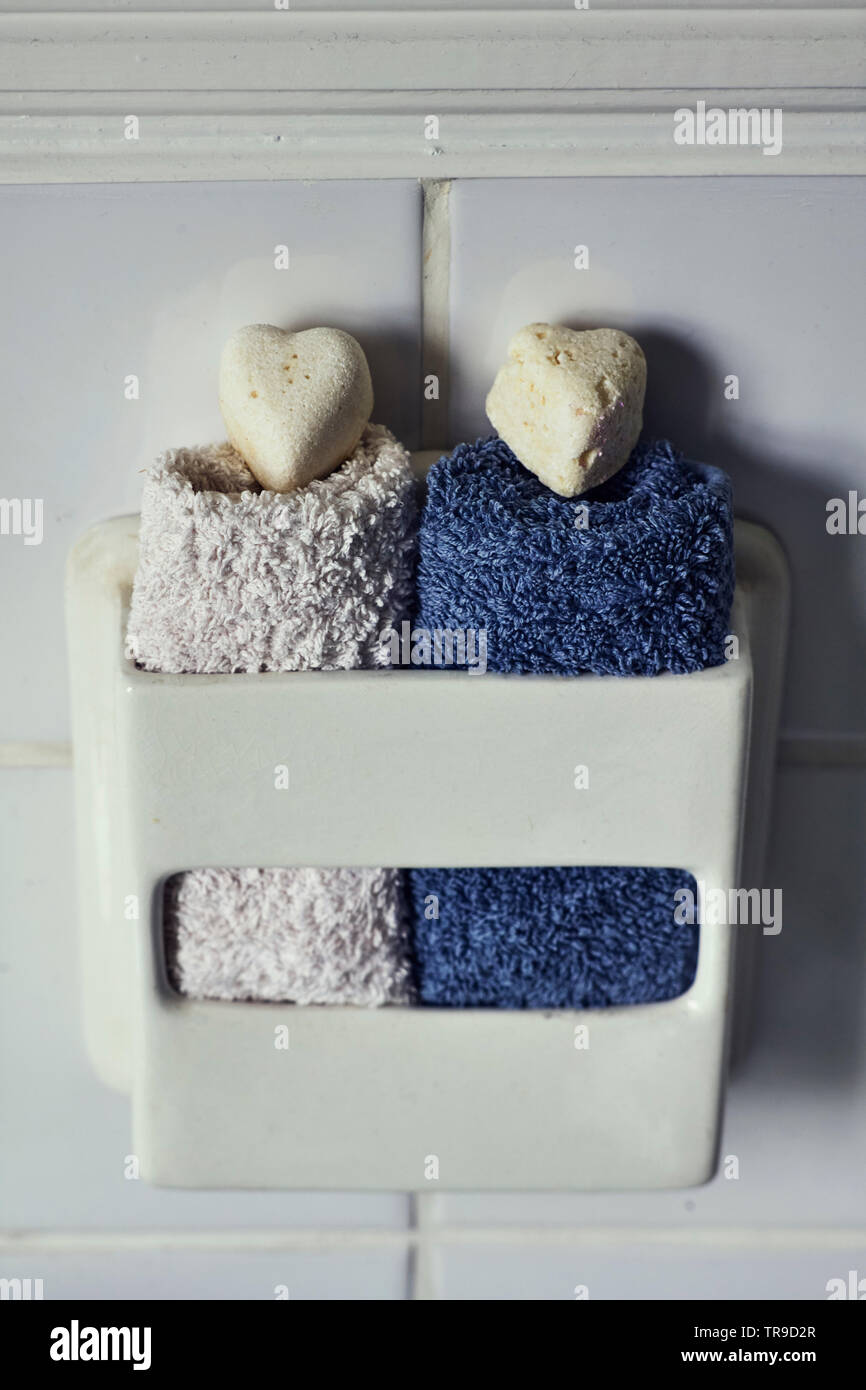 His and hers soaps and flannells together in a traditional toilet paper holder Stock Photo