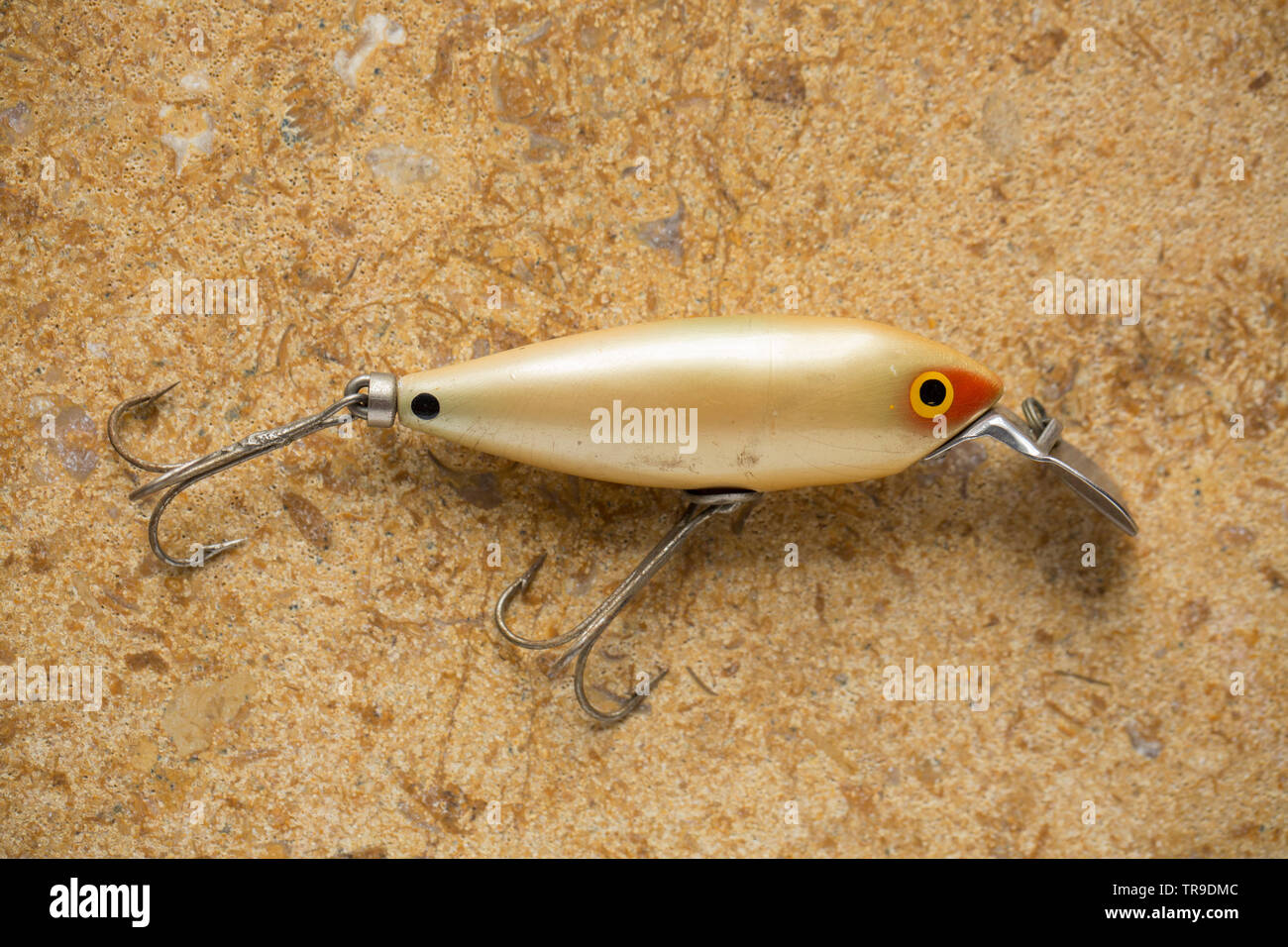 https://c8.alamy.com/comp/TR9DMC/a-vintage-fishing-lure-equipped-with-treble-hooks-photographed-on-a-stone-background-these-type-of-lures-are-often-called-plugs-and-are-designed-to-c-TR9DMC.jpg