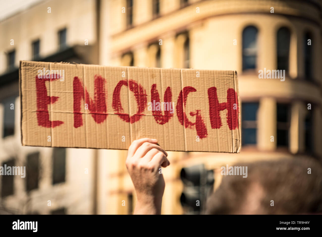 Protester holds up cardboard sign saying 'ENOUGH' at the March for our Lives rally in Washington, DC, USA on March 24, 2018. Stock Photo