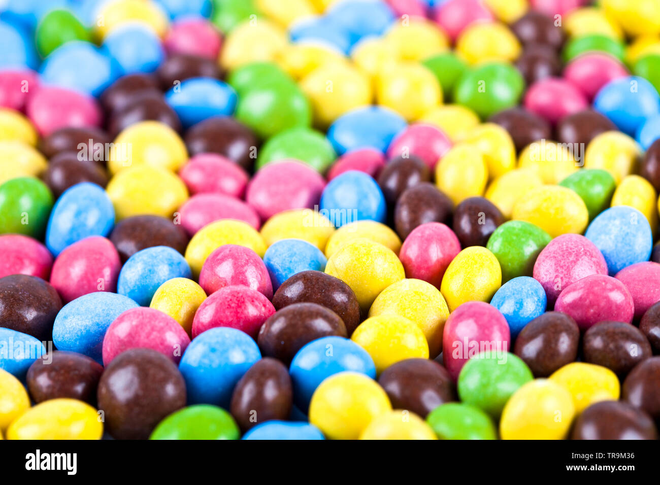 Pile of delicious ainbow colorful chocolate candies background. Macro image. Stock Photo