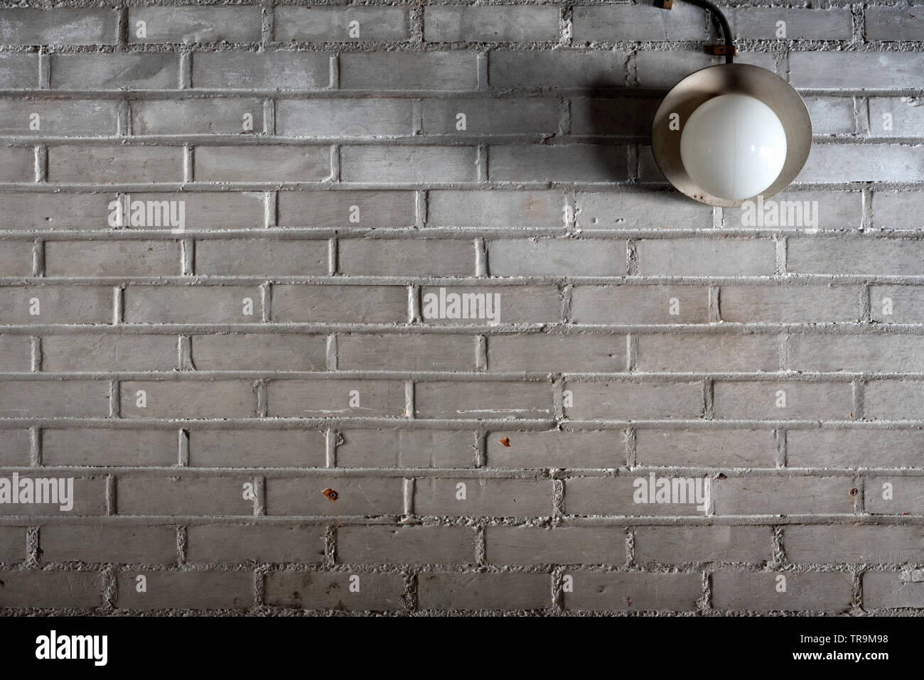Old electric lamp in the garage brick wall Stock Photo