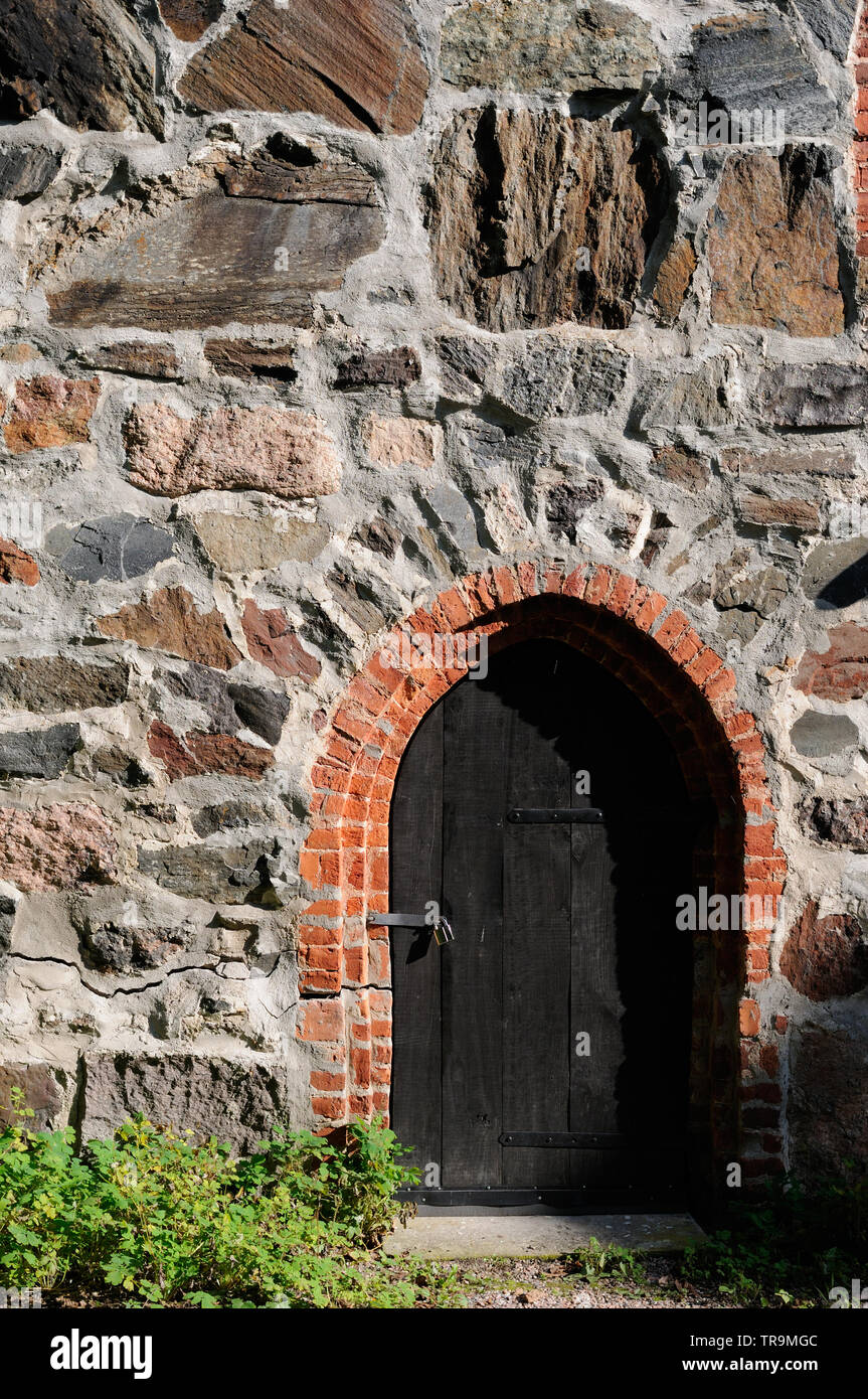 Old dark wooden door in stone wall Stock Photo - Alamy