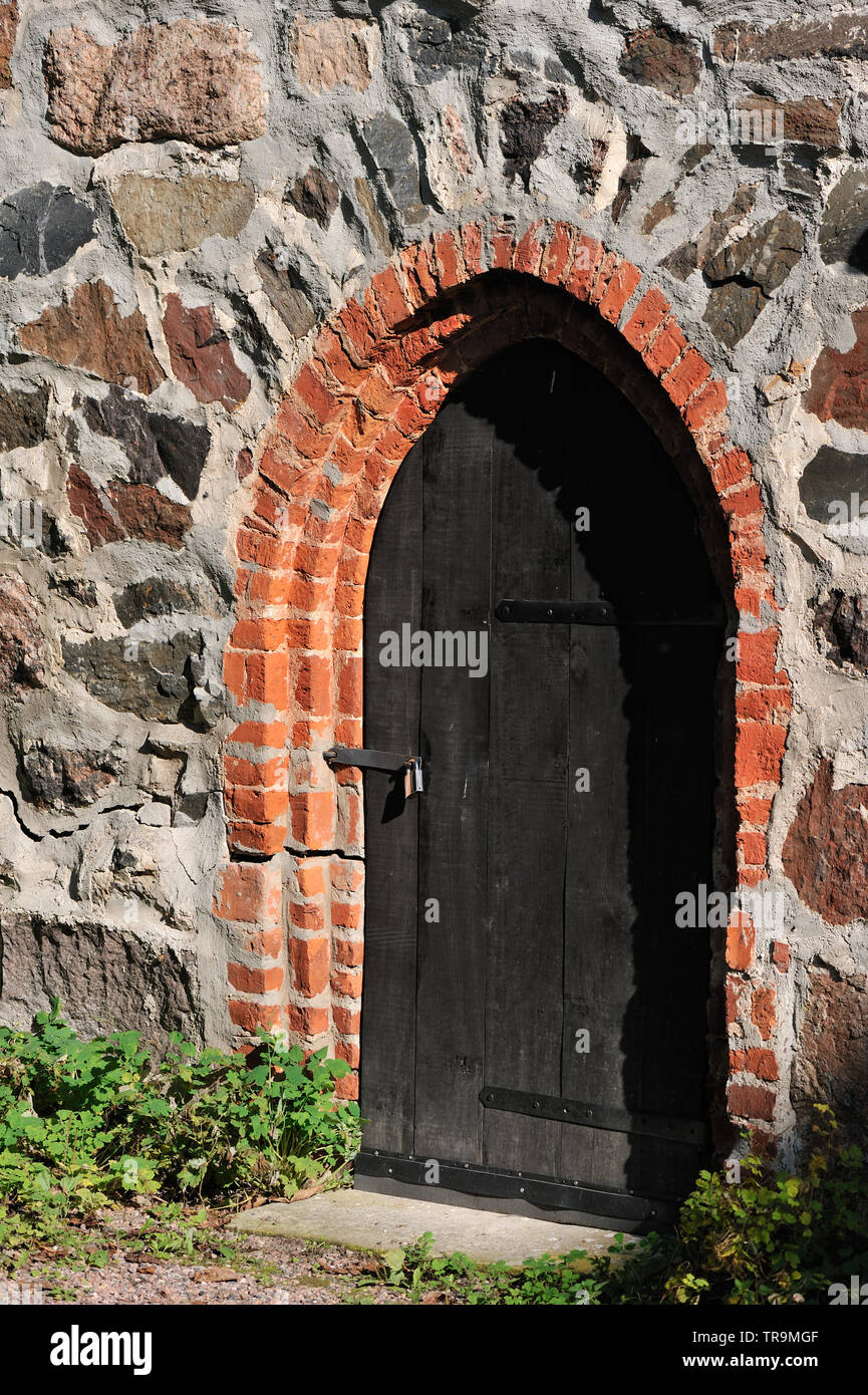Old dark wooden door in stone wall Stock Photo - Alamy