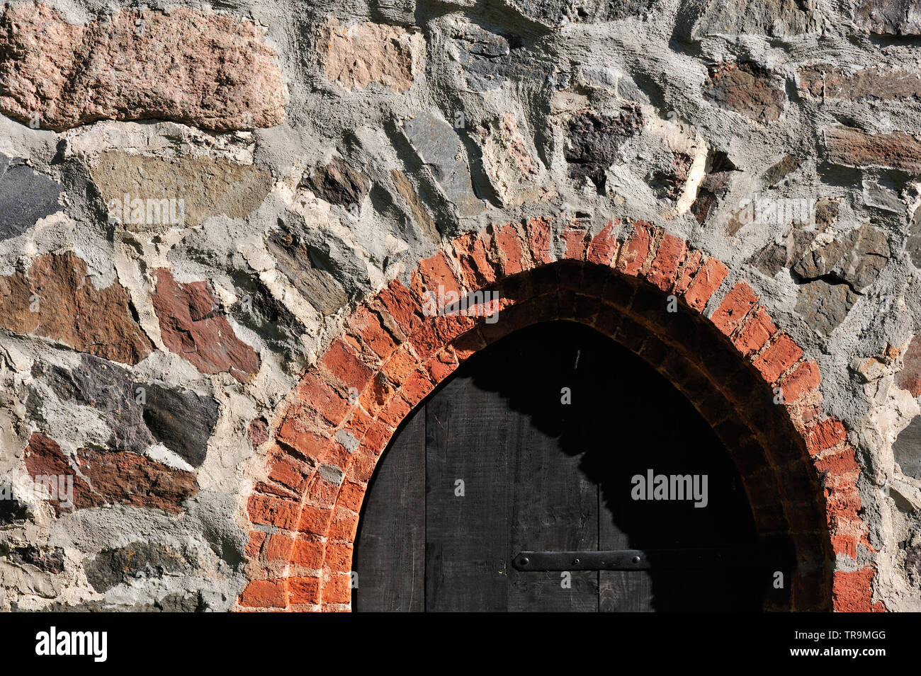 Old dark wooden door in stone wall Stock Photo - Alamy