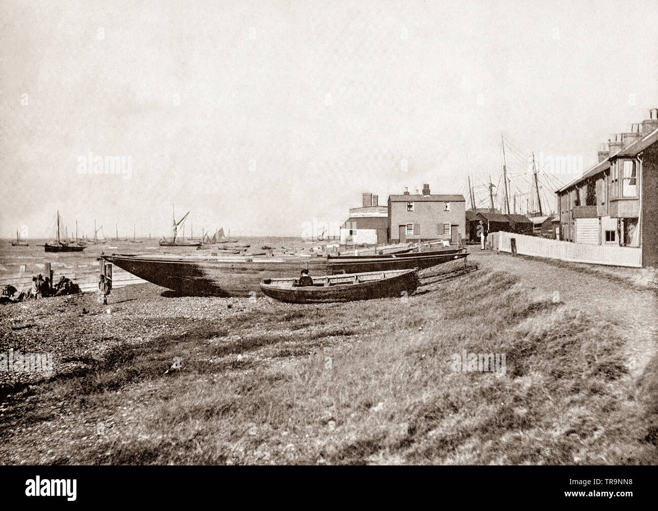 A 19th Century view of sailing boats on the seafront at Whitstable, a seaside town on the north coast of Kent in south-east England and famous for its 'Native Oysters' which were collected from beds beyond the low water mark since Roman times. In 1830, one of the earliest passenger railway services was opened by the Canterbury and Whitstable Railway Company. In 1832, the company built a harbour and extended the line to handle coal and other bulk cargos for the City of Canterbury. Stock Photo