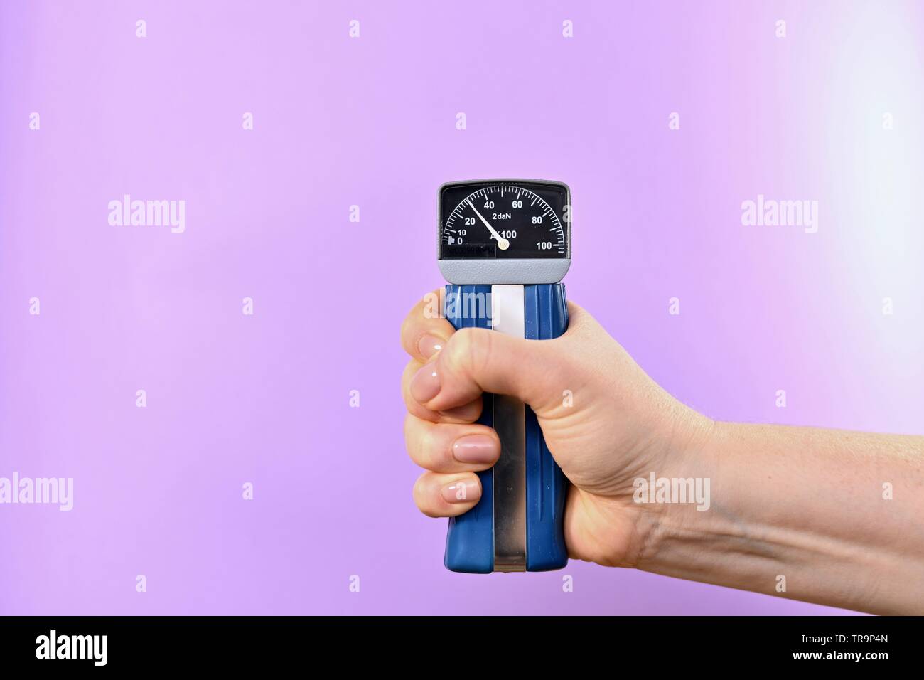 Hand compressive silomer. Mechanical medical research device. On a purple background, center right. Stock Photo