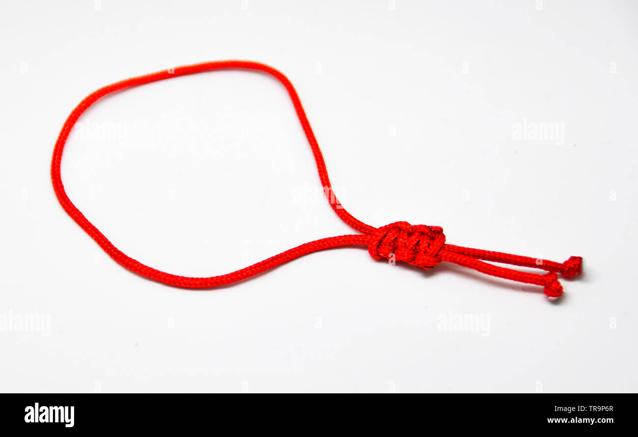 delicate decorative bracelet woven from red rope. Stock Photo