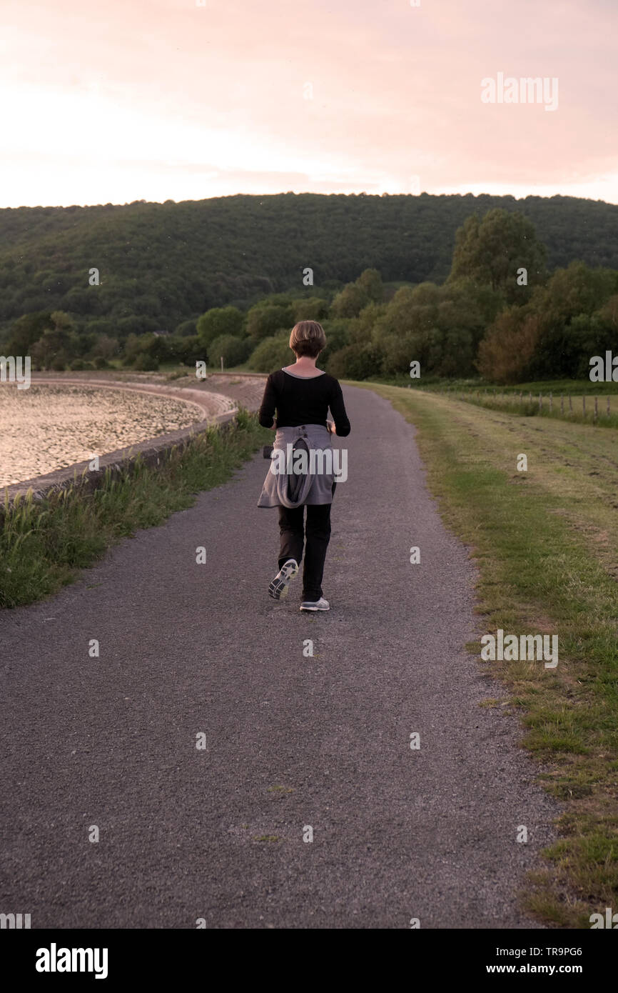 May 2019 - Cheddar res, lone runner around the reservoir perimeter track early evening. Stock Photo
