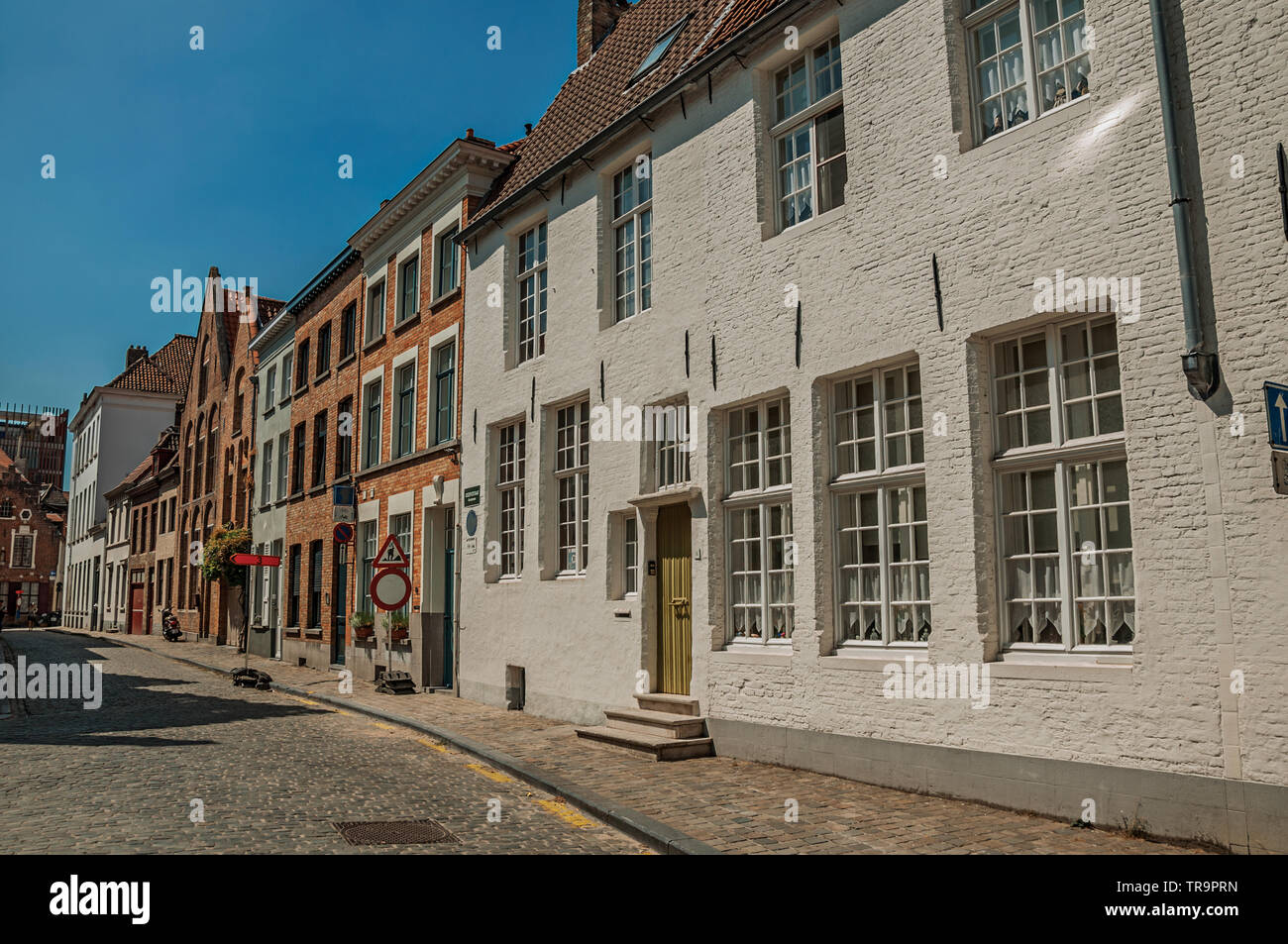 Brick facade of houses in typical style of the Flanders region in street of Bruges. Charming town with canals and old buildings in Belgium. Stock Photo