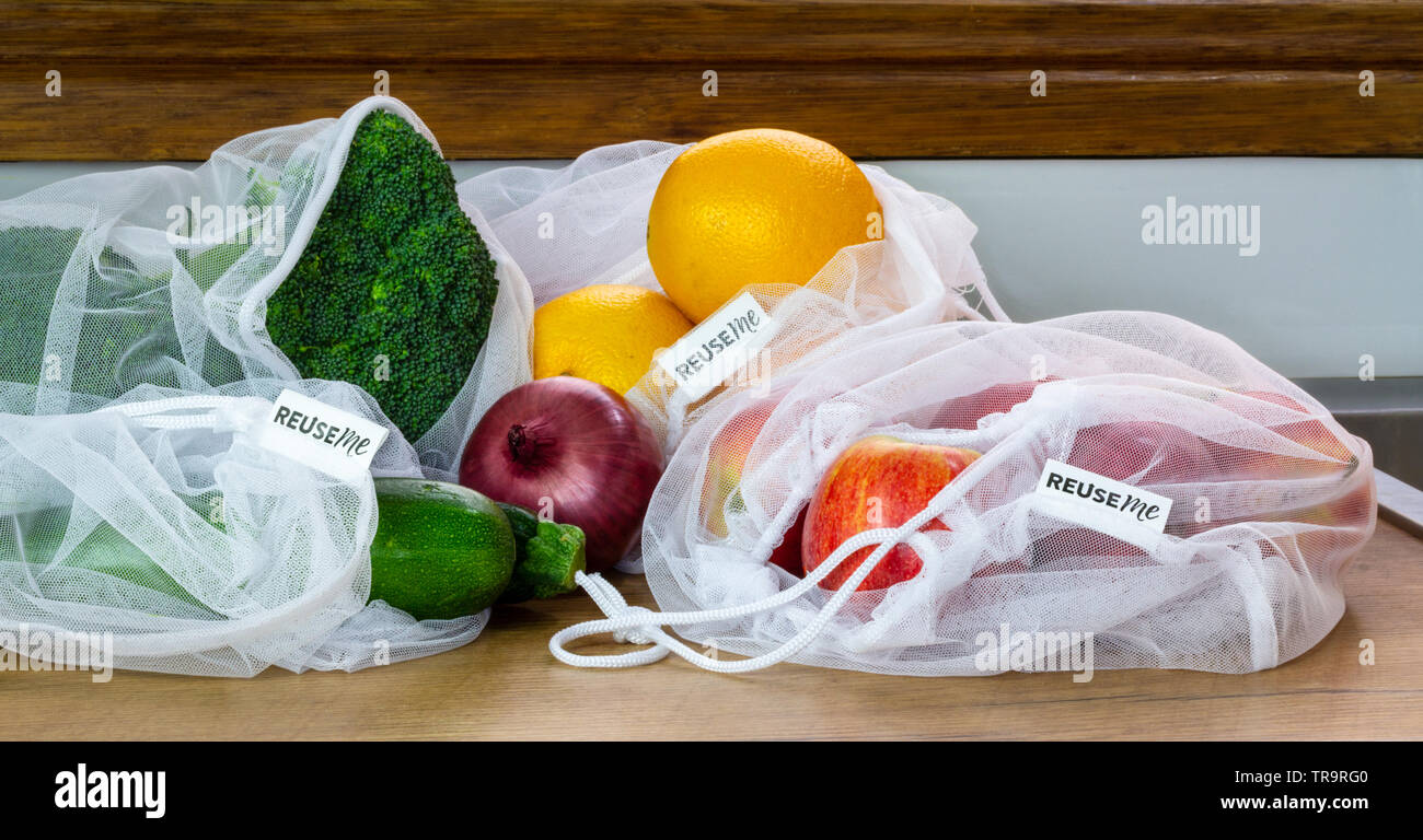 Fruit and Vegetables in reusable mesh bags, with reuse me labels, on kitchen counter, authentic real plastic free eco friendly shopping Stock Photo