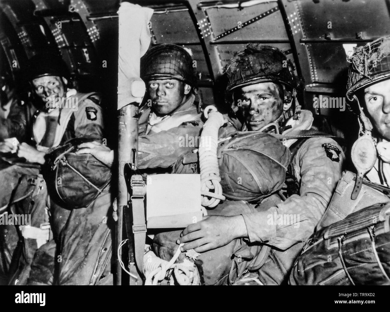 See You in Berlin. Resolute faces of paratroopers just before they took off for the initial assault of D-Day. Paratrooper in foreground has just read General Eisenhower's message of good luck and clasps his bazooka in determination. Note Eisenhower's D-Day order in hands of paratrooper in foreground. June 6, 1944 Stock Photo