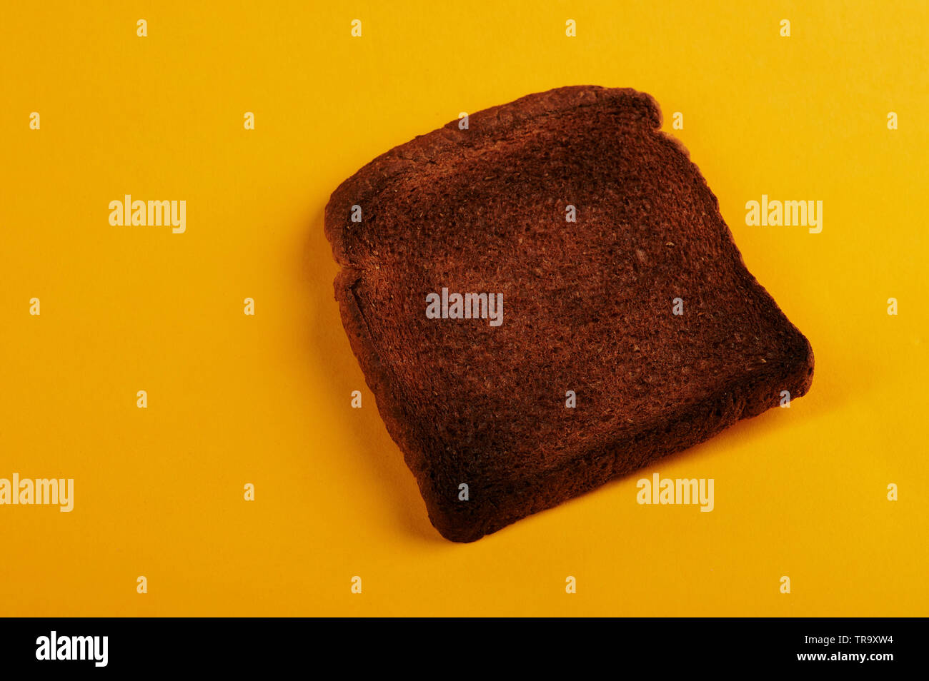 Burnt bread toast lay on yellow background isolated Stock Photo Alamy
