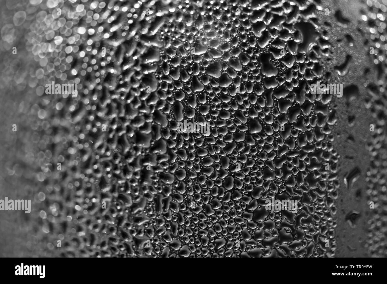Drops on the wall of the bottle, condensation of water on the bottle. Bottle took out of the fridge and formed a sweat. Blurred background Stock Photo