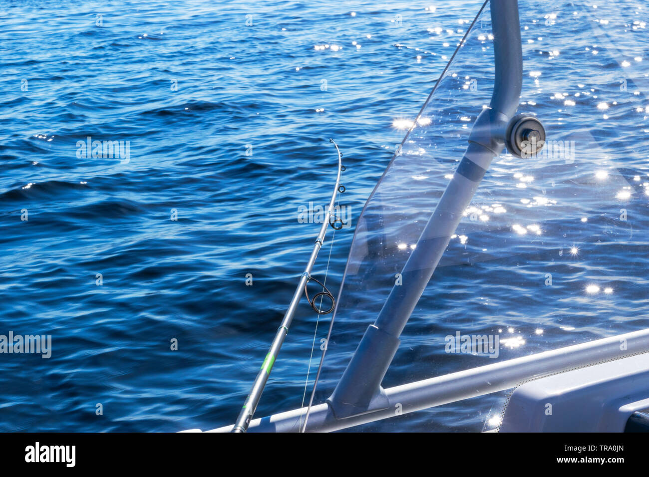 Fishing rod in a saltwater private motor boat during fishery day in blue ocean. Successful
