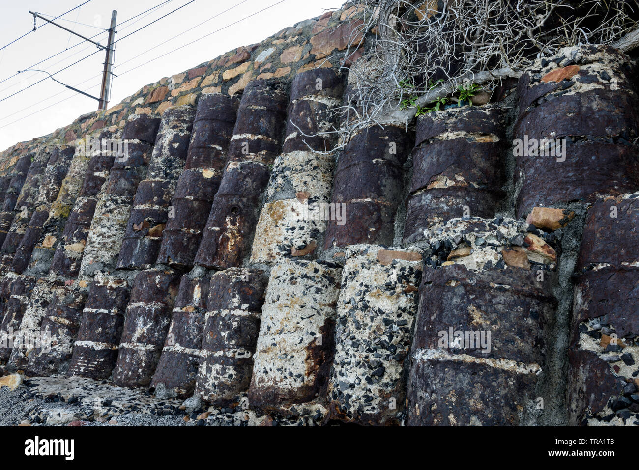 Oil drums filled with concrete act as a support structure on the Cape Peninsula coastal railway between Muizenberg and Simons Town in South Africa Stock Photo