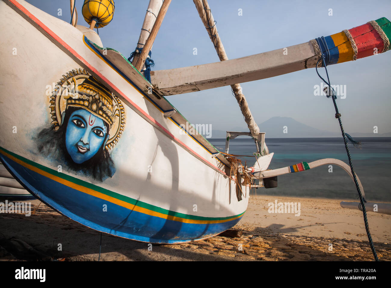 Indonesia Jukung or traditional fishing boat decorated with a beautiful painting of the Hindu God Shiva and anchored on a beach at Nusa Penida Island. Stock Photo