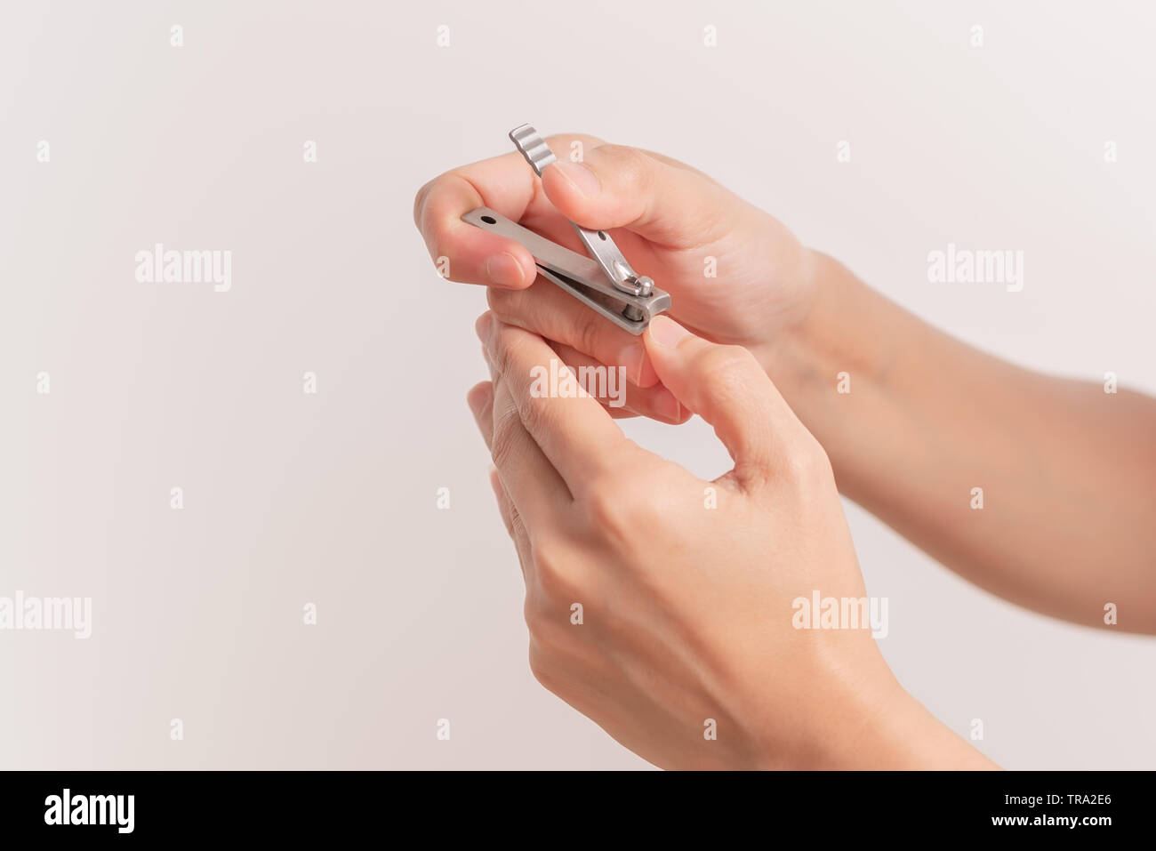 woman hand cutting nails using nail clipper on white backgrounds Stock