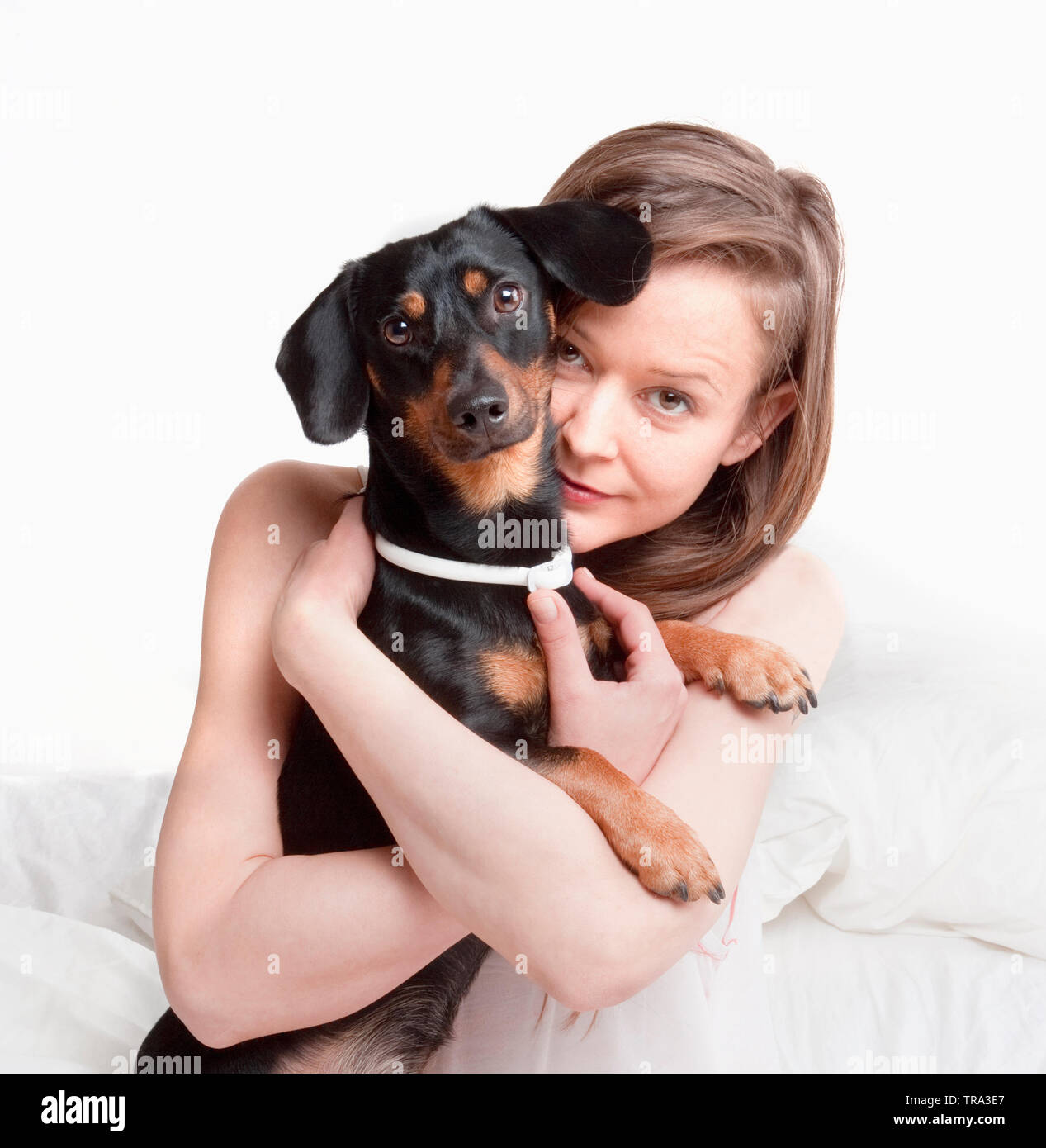 Woman in bed holding her dog. Stock Photo