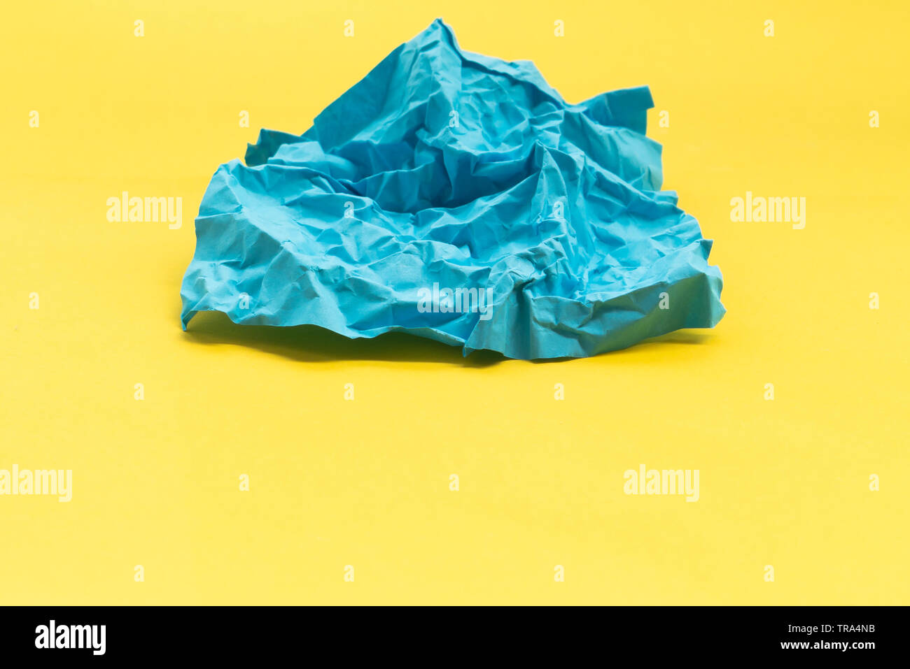 Blue crumpled paper on yellow background, abstract Stock Photo