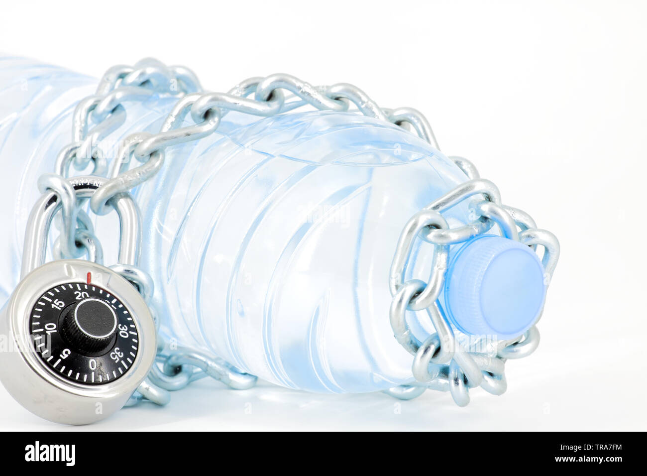Bottle of mineral water locked with chain and padlock on white
