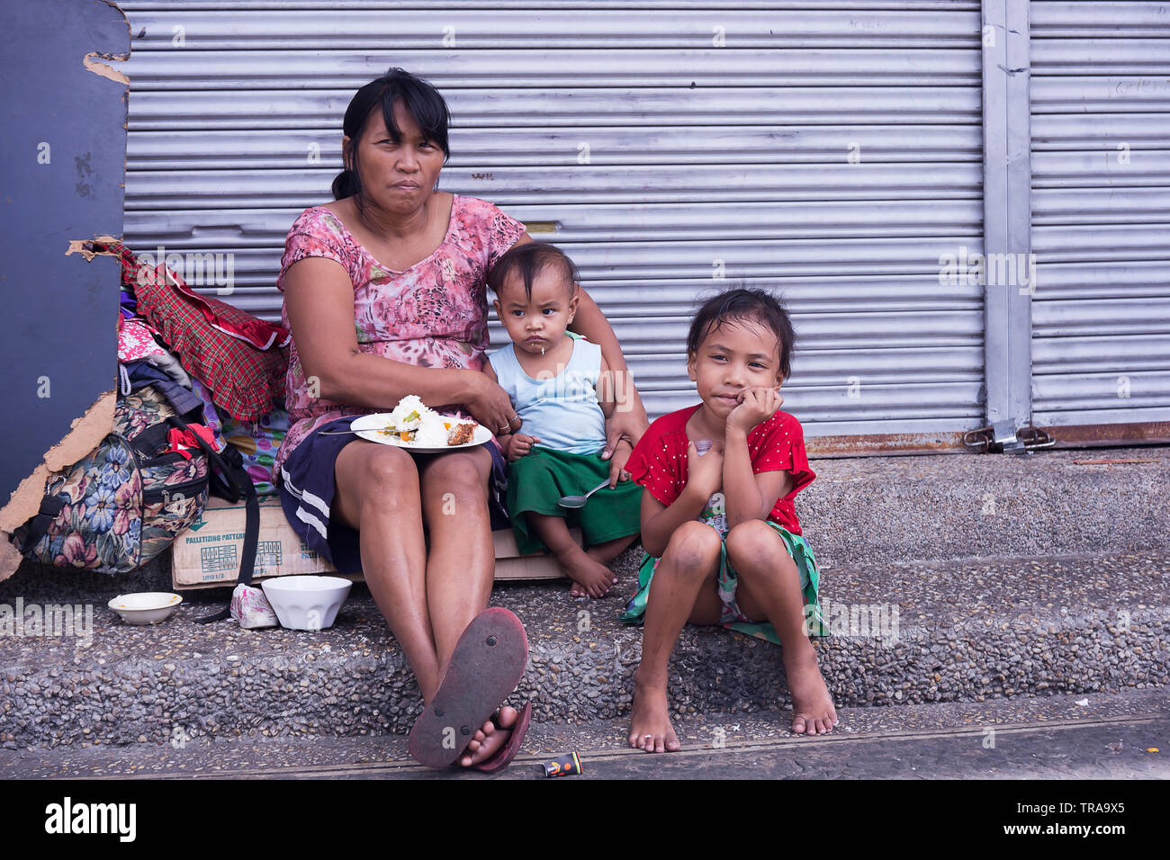 Manila, Philippines - December 21, 2016: Homeless woman with her children Stock Photo