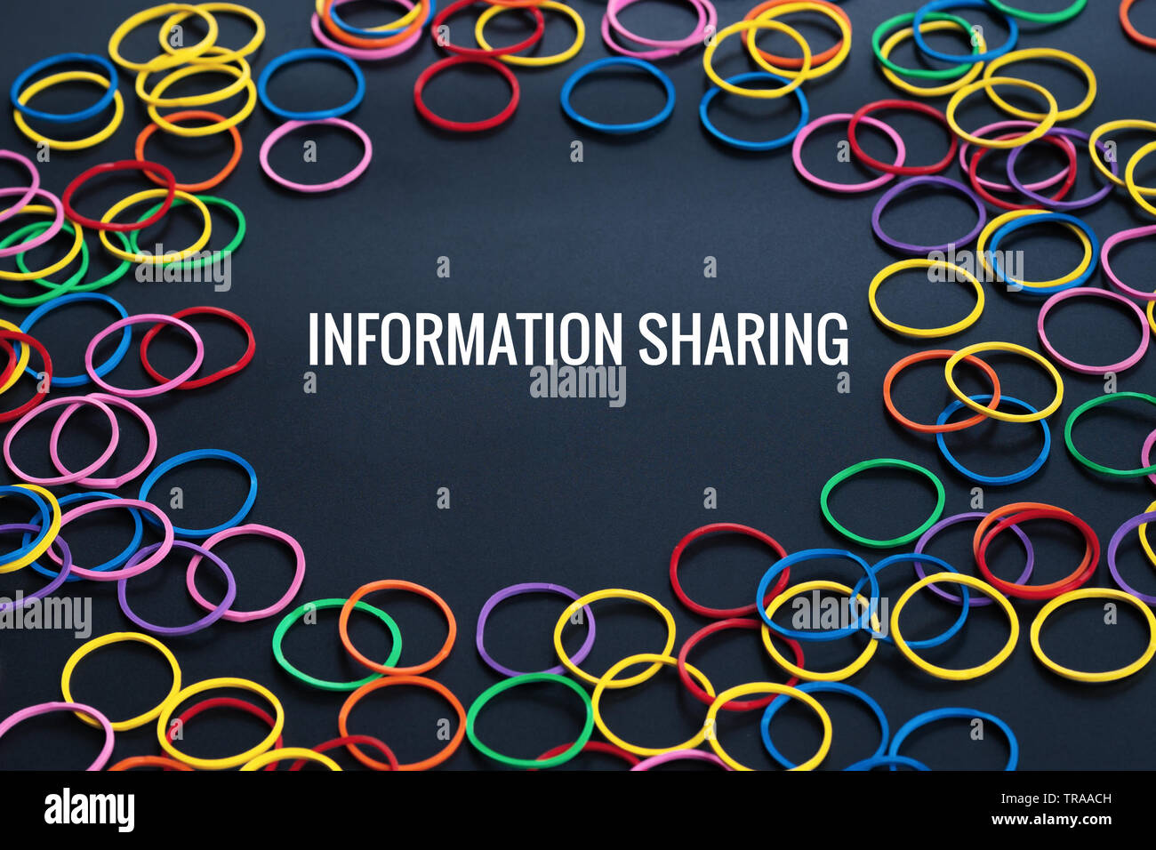 Information sharing concept, colorful rubber band with word Information Sharing on black background Stock Photo