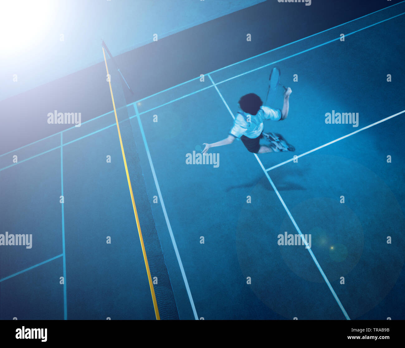 Healthy fit man jumping high on a badminton court smashing the shuttle