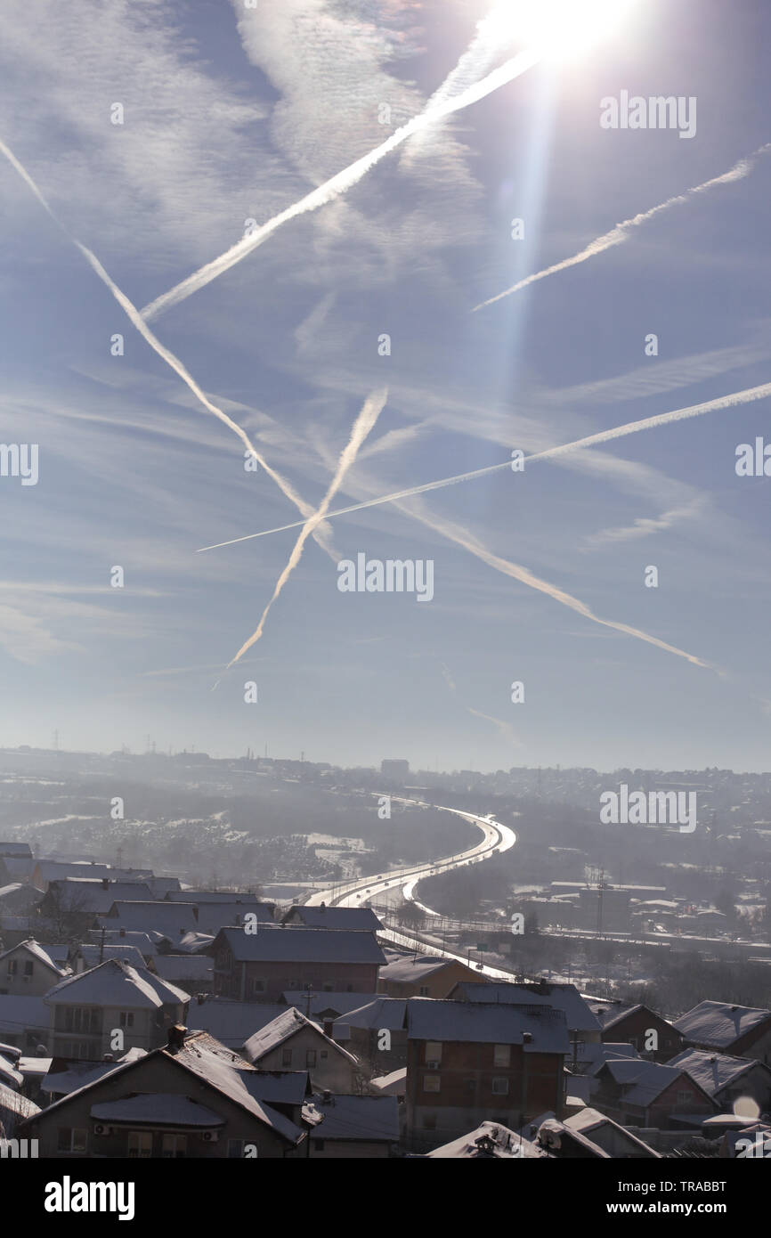 Beautiful winter view of houses and buildings with roofs covered with heavy  snow. In sky see is chemtrails, vapor trails from an airplane Stock Photo -  Alamy, image size:866x1390